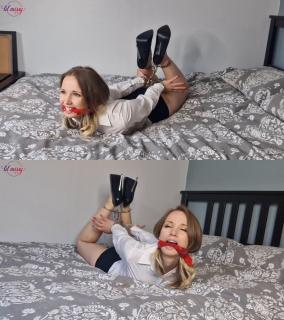 Hogcuffed in high heels and mini skirt In this video I am wearing a tiny microskirt, smart blouse and some very high black stilettos. I've been tightly cleave gagged with a red bandana and hogcuffed to restrict my position.<br><br> <br><br>I struggle on my bed showing off my gagged face and sexy legs. I giggle and smile through my gag as I wiggle around.