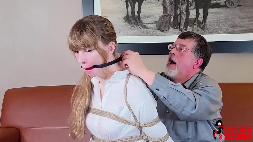 1452 - Introducing Amy Fox! It was such a delight to work with Amy Fox, especially since this was her very first on camera bondage scene anywhere! We were so taken by her that we just had to do an interview with her as she was being bound so you could get to know her too! She talks about her interests, her kinks, and even throws in a few little references to establish her geek cred! All the while, we are slowly, methodically, inescapably and tightly binding her so she can see just what our special brand of bondage is like! The ball gag brings a close to the interview, but you can still enjoy her struggles, her stockinged feet, her long legs and the way her skirt rode up to expose her panties time and again! We think you'll agree: she's one special bondagette!