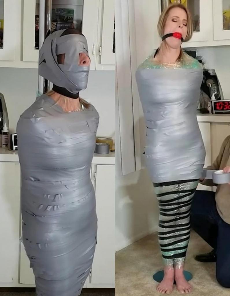 1525 - Claire Irons - Wrapped and Rigid 无助地，她被紧紧包裹在保鲜膜中，将她的身体熔合到钢制支撑物上，将她的挣扎减少到几乎难以察觉的摆动。 现在她完全无助了，她的塑料监狱还被两卷电工胶带紧紧地缠绕在她的身上。 当我在她的茧上再添一层时，她轻轻地咕哝着，这是她所能允许的一切，她试图吸入空气！ 管道胶带缠在可怜的俘虏身上，从脖子到脚的所有地方都被胶带覆盖了！ 她的胸部受到挤压，呼吸变得微弱，因为她的肺部无法再扩张到足以进行深呼吸。 她在整个包裹中呜咽着，手铐深深地扣进了她的腰部。 尽管她被困住了，无法动弹，但没有办法缓解她手腕上的钢铁的咬伤。 当我回来时，我取下了球塞，只是将一个泡沫球塞进她的嘴里，并给她的困境加上了一个紧密的尼龙头罩。 她无法阻止我，我一次又一次地将胶带缠在她的头上，甚至遮住她的眼睛，让她在黑暗中打滚！ 现在连她的头都紧紧地抱住，Helpless, she is then wrapped tightly in plastic wrap, fusing her body to the steel support and reducing her struggles to almost imperceptible wiggles. Now completely helpless, her plastic prison is further secured by two rolls of electrical tape wound tightly up and down her body. Mumbling softly, which is all the gag will allow, she tries to suck in air as I add another layer to her cocoon! Duct tape is wrapped around the poor captive, covering everything from her neck to her feet! Her chest is compressed and her breathing comes in small gasps as her lungs can no longer expand enough for deep breaths.  She mewls throughout her encasement, the handcuffs digging into the small of her back. Trapped and immobilized as she is, there is no way to ease the bite of the steel that encircles her wrists. When I return, I remove the ball gag, only to cram a foam ball into her mouth and add a tight nylon hood to her predicament.  She can do nothing to stop me as I wind the duct tape around her head again and again, even covering her eyes to leave her wallowing in darkness! Now, with even her head held fast,