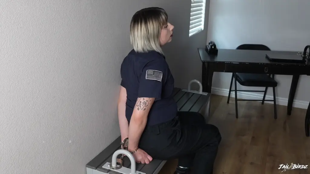 Officer Kaitlynn Day is Arrested pt2 Kaitlynn Day sits on the bench waiting for Lo to return. When she does she removes Kaitlynn’s cuffs and brings her to the interrogation area. She is questioned and fingerprinted before being brought to the mugshot board where her photo is taken and she undresses. Lo places her back in handcuffs and cuffs her to the bench again while she has to wait some more.