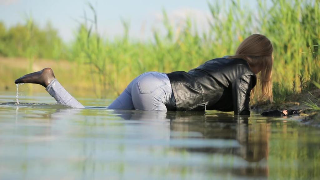 WETLOOK BY CUTE GIRL IN LEATHER JACKET AND WET SKINNY JEANS IN LAKE wetfoto<br>This is Samantha and today she is going to have some fun at the lake. Girl wears black leather jacket, light blue skinny jeans, white blouse and tights - just perfect clothing for wet look. The weather is fine, so she decides to try water. It is a little bit cold but she can not resist to go into the lake - fully clothed. Slowly, girl steps into the shallow water to get used to it. Then she moves forward into the lake. Her light jeans gradually gets wet and darker. Girl lie down, splash the water on her jacket, and blouse to make it soaking wet too. Now, this beautiful girl is fully wet and soaked. With pleasure, she lies down in the shallow water, getting her hair wet. Fully clothed wet girl comes out of the lake several times to watch her clothes dripping and to enjoy her wet look. It is a beautiful day at the lake.