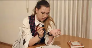 女学生被手铐锁住 她是一位学生，但是她被告知必须戴上手铐，只有在写完论文之后才能被打开，这让她很不舒服，但是她靠自己是完全打不开的