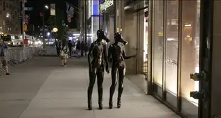 Midtown Strut 乳膠人偶在繁華街道上昂首闊步 (Reflective Desire) 兩隻乳膠人偶在繁華的城市裏昂首闊步，隨意逛街