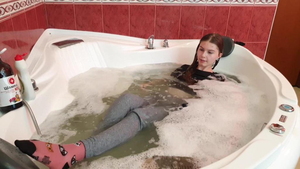 Nastya Made Herself a Bubble Bath and Took It Beautifully! wetlive<br>Nastya went into the bathroom dressed in a dark blue sweat-shirt, gray sweatpants, pink socks with cats, sneakers and a black T-shirt, she was without a bra because she is always so comfortable without it!<br>She went to the washstand and started washing her hands, then she took a hairdryer to completely dry her hair so that it would get wet and feel the weight of the water. Then Nastya began to gradually enter the bathroom filled with water and squat so that she would smoothly get wet from top to bottom! She sat down on her knees and started spraying herself with water! The spray flew all over her body and belongings, then she took a shower can in her hands and began to wet her hair and face!<br>The water flowed so nicely through her hair, creating tension in her hair, and when it was already difficult to breathe in the tight wet clothes, she began to take off her sweat-shirt and squeeze a lot of water out of it!<br>Then she took a bottle of detergent in her hands and began to wash her breasts, the foam was very clearly visible on the black T-shirt! She poured more detergent into her hands and began to make a lot of foam in her water, then she played with the foam and tossed it!<br>Nastya showed her wet socks and we didn't even notice how she took off her wet shoes! It was a hot bath and was very beautifully filmed and photographed!