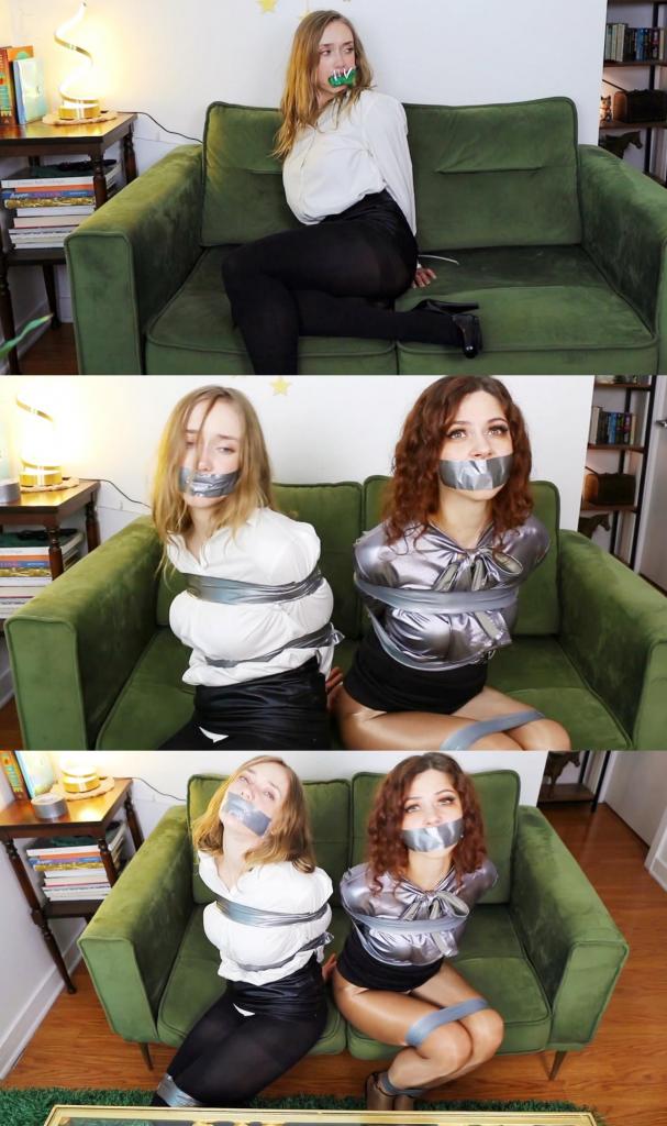 Jade Rose and Mina Salome: Tightly tied up and tape gagged detectives captured by a criminal magicia Jade Rose and Mina Salome: Tightly tied up and tape gagged detectives captured by a criminal magician (PART 2)第 2 部分：在坏人准备他偷来的魔法装备时，米娜和杰德被绑着、堵着嘴，度过了几个小时，现在是时候去他的藏身之处并运送他的俘虏了。他们到了他的地方，杰德被一条束线带绑住，嘴里塞着一只袜子，并用透明胶带固定。到达他的地方后，坏人解开了杰德，因为束线带太紧了，而且他并不是那么坏人，但这次他仍然用胶带绑住她，并再次用银色胶带堵住她的嘴。米娜也被束线带绑住，但坏人只是用胶带缠住束线带，所以米娜完全没有机会挣脱。被绑住并堵住嘴后，两位侦探都在挣扎，直到意识到他们无法挣脱，他们必须等到获救！PART 2: Mina and Jade spent a couple of hours tied and gagged while the bad guy prepares the magic gear he stole, now it is time to go to his hideout and transport his captives with him. They arrive to his place, Jade is tied with a zip tie, gagged with a sock stuffed in her mouth and secured it with clear tape. Once in his place, the bad guy unties Jade, as the zip tie is too tight and he is not that bad of a person, but still ties her again this time using duct tape, and gags her again with silver tape. Mina is also zip tied but the bad guy simply wraps duct tape over the zip tie, so Mina has zero chance to get free. Bound and gagged, both detectives struggle until realizing they won't be able to break their bonds and they will have to wait until they get rescued!