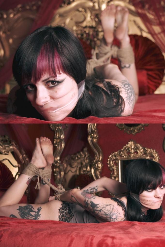 Larz Hogtied 拉兹被捆绑着，嘴里塞着透明胶带，当然，还光着脚。<br><br>她开玩笑似的说着话，而且哪儿也不去。但她没有抱怨，因为她在红屋里过着奢华的生活。Larz is hogtied, tape gagged with clear tape, and of course, barefoot.<br><br>She's playful in her gag talking, and she's not going anywhere. She's not complaining though, because she's in the lap of luxury in The Red Room. 