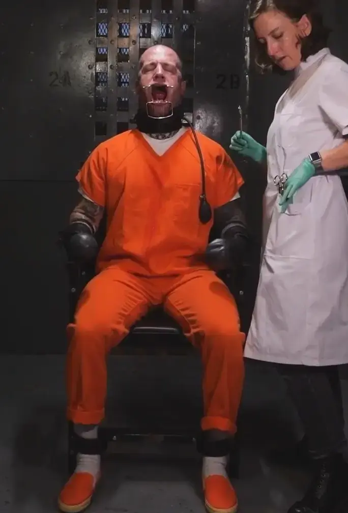Prison Dentist - Heavy and Elise Graves - Solitary confinement prisoner receives an unpleasant visit Prison Dentist - Heavy and Elise Graves - Solitary confinement prisoner receives an unpleasant visit from the sadistic prison dentist当你被判处最高安全监狱的监禁时，生活并不美好。没有逃脱的希望，也没有获得自由的机会。如果你发现自己被单独监禁，情况会更糟。没有人可以交谈，没有人可以帮你打发时间。Heavy 发现自己被单独监禁。由于最近的一些错误决定，包括向警卫吐痰，Heavy 现在不仅被单独监禁在最高安全监狱，而且还受到最大程度的约束，这意味着他们不再被允许自由使用他们的手臂、腿或嘴巴。这是一种严厉的惩罚，但俗话说：随便玩一玩就知道了。Heavy 多年来一直在牢房里受苦，尽管他们非常渴望与人接触，但监狱牙医来访的消息并不受欢迎。Heavy 记得去年的探访——那并不好。今年，由于对他们身体的极端限制，情况变得更糟——监狱牙医现在完全控制了他们！尽管 Heavy 希望 Elise 博士能心地善良，但 Heavy 却无法忘记她在他们敏感的嘴里挥舞金属工具时露出的施虐笑容。哦不，她来了！Life is not great when you are sentenced to a maximum security prison. No hope of escape, no chance at freedom. It gets much worse if you find yourself in solitary confinement. No one to talk with, no one to help pass the time with. This is where Heavy finds themself - in solitary. Due to some recent poor decision-making including spitting at a guard, Heavy is now not only in solitary confinement in a maximum security prison, but they are also on maximum restraint, which means they are not allowed the free use of their arms, legs or mouth anymore. This is a severe punishment, but as the saying goes: fuck around and find out. Heavy has been languishing in their cell for years now, and although they desperately crave human contact, the news that the prison dentist is making a visit is not exactly welcomed. Heavy remembers last year’s visit - it was not good. This year, it is made much worse due to the extreme restriction of their body - the prison dentist now has complete control! Though Heavy hopes that Dr. Elise will be kind, Heavy can’t forget the sadistic smile she gets when wielding her metal tools in their sensitive mouth. Oh no, here she comes!