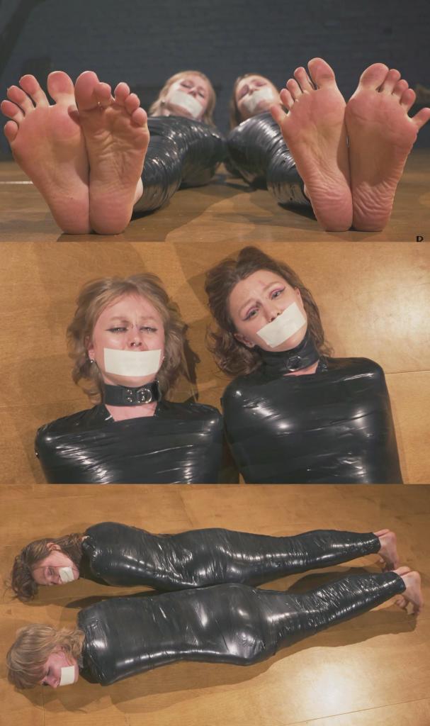 Mandy and Bramble - Double Tight PVC Mummification Part 2 - Struggling on the Floor 在这段视频中，两位木乃伊美女 Mandy 和 Bramble 躺在地板上，在紧身的 PVC 胶带茧中嬉戏打闹。摄像机捕捉到她们赤裸的双脚、表情丰富的脸庞以及她们在紧身包裹中扭动的每一个动作。<br><br>这两个女孩积极地扭动身体，考验她们的木乃伊形态。有一次，Mandy 的茧在她背后出现了一个小裂口，当然，她很快就把它修补好了，然后退后一步，让她们继续木乃伊体验。<br><br>两位女士的嘴都被微泡胶带封住，为她们的困境增添了额外的约束力。尽情享受吧！In this clip, the two mummified beauties Mandy and Bramble lie on the floor, struggling playfully in their snug PVC tape cocoons. The camera captures detailed shots of their bare feet, expressive faces, and every movement as they wriggle in their tight wraps.<br><br>The girls actively twist and turn, putting their mummified forms to the test. At one point, Mandy's cocoon develops a small tear around her backside, which is, of course, quickly patched up before stepping back to let them continue their mummified experience.<br><br>Both ladies have their mouths sealed with strips of microfoam tape, adding an extra touch of restraint to their predicament. Enjoy!