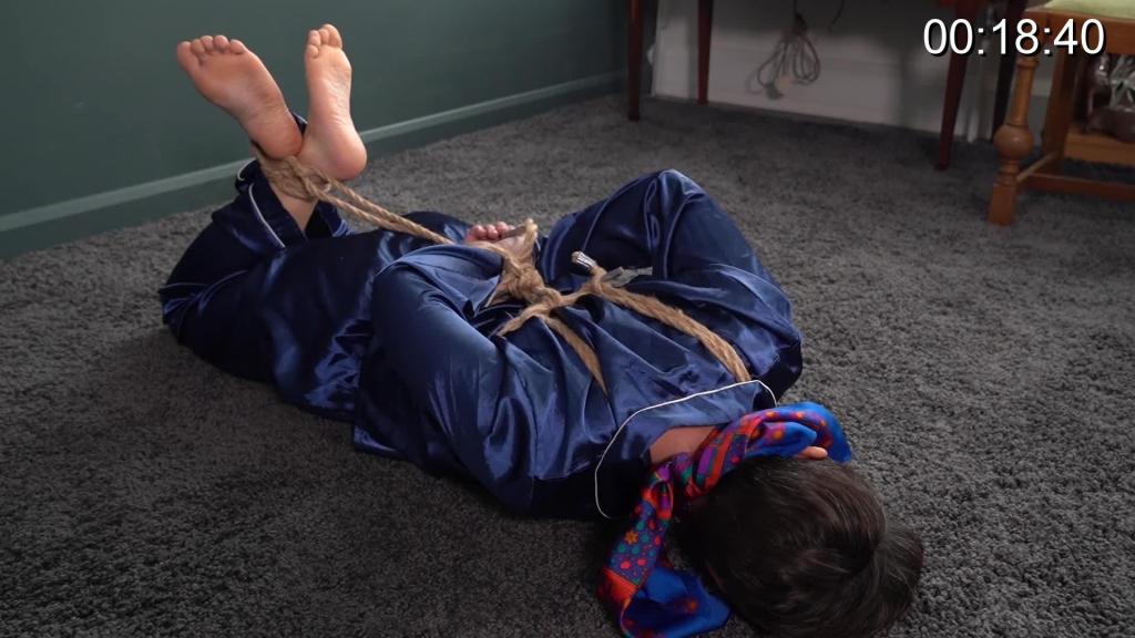 3033 Jesse in Satin Pyjamas Twice Tied Jesse is wearing lovely blue pyjamas. First she is tied to a chair. Not too happy about her toes then being tied to the chair too. Next, hogtied in a cross ankle barefoot hogtie and a satin scarf used as a gag.
