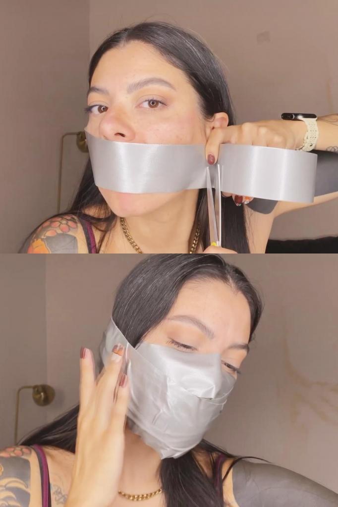 Liricaa does a duct tape gag 有人告诉 Liricaa 她必须保持安静，当然，她能做到这一点的唯一方法就是堵住自己的嘴。<br>所以，她抓起胶带。但首先，要塞住嘴！她把袜子塞进嘴里，然后用胶带先在嘴和鼻子上贴几条胶带，然后她在嘴上缠上很多很多胶带，最终形成一个巨大的堵嘴，覆盖了她的整个嘴和鼻子，从眼睛下面到下巴下面。这是保持安静的完美方法。Liricaa has been told she needs to remain quiet and of course, the only way that she can do that is by gagging herself. <br>So, she grabs so duct tape. But first, stuffing! She stuff some socks into her mouth and the with the duct tape she first adds some strips of tape over her mouth and over her nose, after that she rolls loads and loads of tape around her mouth, achieving a massive gag that covers all her mouth and nose, from right under her eyes to under her chin. Perfect way to remain quiet. 
