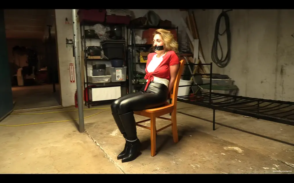 The Loan Officer (MP4 1080p) - Alba Zevon After Alba, the loan officer at a high street bank, declines a loan to Rick, he decides to exact revenge by grabbing her as she leaves work. We join her as Rick opens the trunk of his car where Albas hand are zip tied behind her back and she is already gagged with duct tape. Rather than submit passively, Alba kicks her assailant and makes a run for it. Running in high heels slows her down badly and Rick soon catches up to her. He secures her ankles with a zip tie before throwing her over his shoulder and carrying her back towards his house, specifically to his garage. He zip ties Alba to a chair then removes her gag. She demands to know what he wants, and the answer is simple. If she approves his loan, he will let her go, otherwise she will stay there. Alba tells him he is a fool to think he could get away with this, so Rick cleave gags her and leaves her alone to think about her situation.