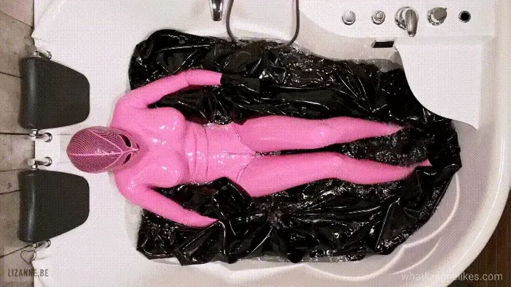 00263 - A sheet in the tub It was so much fun to bathe in latex. Even though I couldn´t see a thing, it was so exciting so feel the sheet going through my hands and to feel it slide over and under my latex encased body. The sounds were also incredible. The weight of the sheet is crazy, it´s impossible for me to lift it all by myself. For those who are curious, the sheet is 5x4m and 0,40 mm. Talking about heavy rubber ????<br>I never thought I would ever wear a bubblegum pink outfit, but I´m so happy with it, it matches so well with black. I also love the combination of the two hoods, I hope you do too! So, do you think there´s room for one more? ????