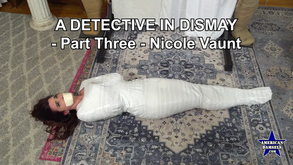 A Detective In Dismay - Part Three - Nicole Vaunt Private investigator Nicole Vaunt has been taken by a masked villain to his hideout somewhere in an abandoned industrial area. He's decorated his lair with some Halloween mummies in an attempt to intimidate his luscious guest. But the plucky detective isn't fazed by this, even though her wicked host has wrapped Nicole up in duct tape in a position mimicking the the mummies on either side of her. The bad guy is still demanding that the luscious P.I. divulge the location of a mysterious film, but she refuses to comply. The black-clad baddie decides to give the contrary gumshoe some time to rethink her answer, and he tapegags her. Detective Vaunt uses her strictly limited movement to try to wiggle out of her sticky bondage, aware that escape is impossible, but knowing she has no choice but to try anyway. Then our brave damsel is moved onto the floor, her tape mummification nearly complete. The evil man informs her he's run out of tape and needs to make a quick trip to the hardware store for more so he can finish the job. Alone again, Nicole valiantly tries to extricate herself from the tenacious binding. What fate awaits our sexy sleuth now?<br><br>私人侦探 Nicole Vaunt 被一名戴面具的恶徒带到他隐藏在废弃工业区的巢穴。他用一些万圣节木乃伊装饰他的巢穴，试图恐吓这位迷人的客人。但勇敢的侦探并未被吓倒，尽管她的邪恶主人已经用胶带将 Nicole 捆绑起来，姿势模仿两侧的木乃伊。<br><br>坏人仍然要求这位迷人的侦探透露一部神秘影片的下落，但她拒绝配合。身穿黑衣的恶徒决定给倔强的侦探一些时间重新考虑答案，并用胶带塞住她的嘴。Vaunt 侦探利用极其有限的活动范围试图从粘性束缚中挣脱，明知逃脱不可能，但仍别无选择，只能尝试。<br><br>随后，这位勇敢的女士被移到地板上，她的胶带木乃伊化几乎完成。邪恶的男子告诉她，他的胶带用完了，需要快速去五金店买更多，以便完成捆绑。独自一人时，Nicole 英勇地尝试从顽固的束缚中解脱出来。<br><br>现在，这位性感的侦探会面临怎样的命运呢？<br>