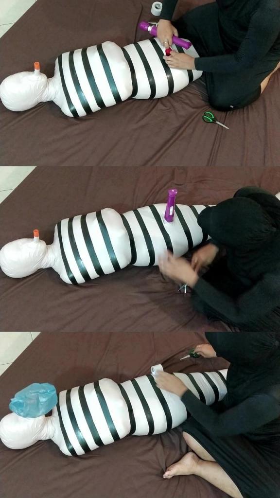[POV] Main Scene Of RandyMummify RM143 A girl is mummified using white duct tape. After being wrapped all over the body, it was reinforced with black duct tape. This girl's body became like a convict mummy ready to be trained. This girl is then given a breath from a small tube and then the breath hole is closed with plastic.