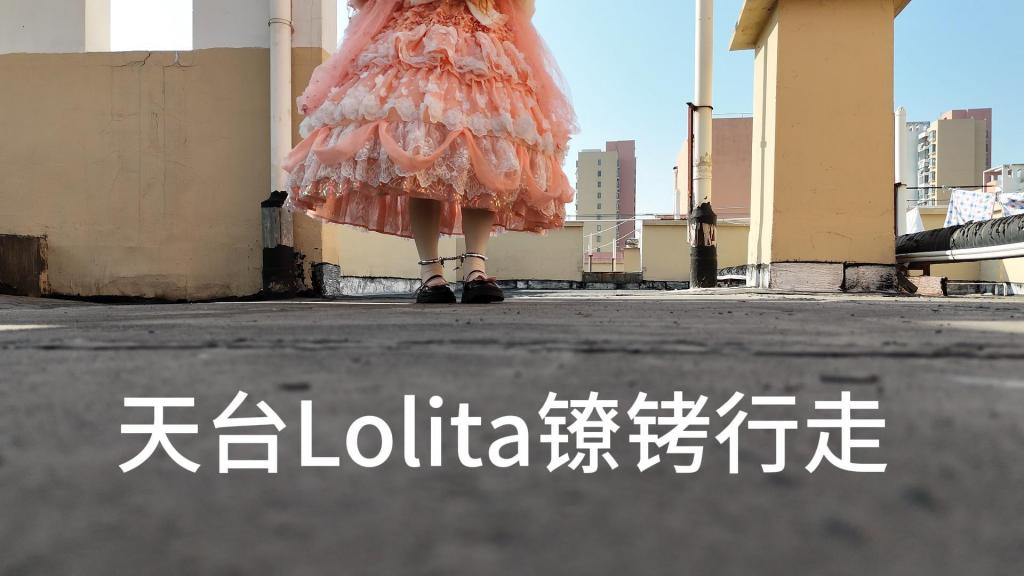 无人机拍摄的天台楼顶Lolita手铐脚铐自缚行走 无声视频 打扮好来到楼顶，带上了手铐和脚镣，调整视角，准备开拍……<br>先把脚镣戴上，这下想跑也跑不掉了，时刻会担心有人上楼顶收被子，主打一个刺激，稍微走一段，到隔壁楼顶看看，希望不会突然上来人吧,周围的楼都比我所在的楼层高，希望没人会看到吧<br>紧接着把手铐戴上，玩了一会想解开发现拿不下来了，这下是真的好玩了，不解开是真的下不去了，因为楼顶有个管道挡着，戴个脚镣跨不过去，要解开脚镣就去必须先打开手铐，但是现在手铐在后面卡住了，拿不下来了……