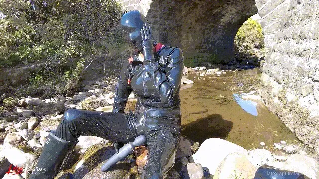????DAILY LATEX????Rubber hike continuation After I had enjoyed my "Magic Friend", I continued my hike. I followed a small stream and discovered a bridge. I sat down under the bridge. The cars drove over me and my pussy was itching again in this public atmosphere. Magic Wand part 2. Afterwards I took a sunbath right next to the road. I hope the rubber doll didn't distract the drivers too much.