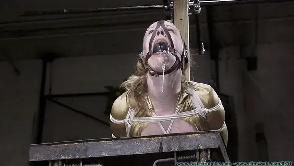 Huge Gags, Drool, and a Reverse Prayer Hogtie for Moxie - Part 4 This clip starts where Part 3 ended... Moxie lays on the table for a few moments before I walk over and put her in a strict hogtie. She seems to struggle with the tightness at first, but soon she settles in. I tie her head way back utilizing the D-ring on her harness gag. Drool bubbles up around the ball and runs down her chin. I remind her that she wanted to bound and made to drool and I think she can do better, so she starts forcing the drool out from behind the gag. Soon copious amounts of drool are streaming down her chin and onto the table. I leave her hogtied on her stomach for a while, but I eventually roll her onto her side so we can get a different view. I leave her again. Moxie is glassy eyed and completely zoned out by now, thoroughly enjoying her bondage. After a while, I know it's time for her to come out of her bondage as, by this time she has been in it for a long time. I smear her drool all over her face and tits. I run my hands over her bound body and once again give her crotchrope a tug. I remove her gag and put my hands around her throat as I pull on her crotchrope. Moxie is completely out of it, but responds nicely. I then start cutting the ropes off her slowly so you can see her reactions as the ropes slowly loosen up. NOTES: This clip was done as a custom from a customer who likes my rope work, but doesn't like the spanking, nipple clamps, etc. Everything in this clip fell together perfectly and Moxie and I both very much enjoyed making it, even though it is not quite in line with my normal style. The theme for the video was drool, and I think we accomplished that.
