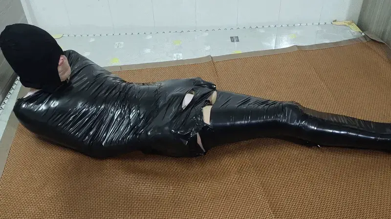 黑胶布全包自缚(伪娘) 一直以来，我都习惯一个人沉浸在自缚的极致快感里，脑海中反复幻想着——要是有人能把我彻底全包起来，那该有多爽？<br><br>那天晚上，我裹着棉被翻滚自缚时，突然灵光一闪：用胶布先在地上粘贴出一个巨大的平面，再躺上去尽情翻滚，胶布就会自动收紧，把全身层层裹死！想到就干，我立刻行动！<br><br>为了降低难度，我先从屁股以下开始，用宽胶布把下半身一圈圈包裹得严严实实，同时在最敏感的位置贴上电击贴，让自己在被束缚的同时，也能被电流一次次冲击得又爽又颤。准备就绪后，一切如我预想的那样顺利——我成功完成了全身全包！胶布紧紧贴合每一寸肌肤，把我裹成一个无法动弹的“人形粽子”，那被完全控制的窒息快感，简直爽到骨子里。<br><br>我兴奋地挣扎了一会儿，却突然发现……一时半会儿根本解不开！心跳瞬间飙到顶点，彻底慌了神。接下来，我像疯了一样奋力扭动、翻滚，全身被汗水浸透，肌肉绷紧到极限，胶布却越勒越紧……终于，在最后关头，我用手指死死抠开了一道口子，成功挣脱出来！<br><br>那种从绝境边缘逃出生天的刺激，混着满身大汗和余韵，简直让人上瘾到爆炸！
