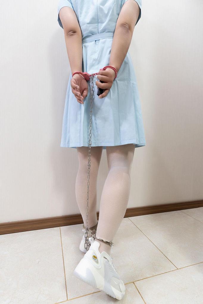 东莞校服礼裙的制服镣铐诱惑 - 社团活动室的角落里堆满了万圣节装饰，南瓜灯咧着牙齿，蛛网在窗边摇曳...身上的浅蓝色校服礼裙在灯光下泛着柔和的光，白色薄裤袜包裹的小腿，脚上的运动鞋却与这身装扮格格不入，但却让她感到十分安心。“试试这个！”社长递过来衣服一副的玩具手铐，玩具似的颜色让她毫无戒备。还没来得及反应，“咔哒”一声，镣铐瞬间将双手链接，手腕立刻感到了沉甸甸的金属重量。“等等，这钥匙...”社长一遍坏笑着，一边掏出一副银色脚铐按在她双脚间....本能式的扭动身体，金属摩擦的细响声在安静的房间格外清晰，手腕间的一抹粉色在灯光下显得天真又诡异，锁芯深处传来机械精密咬合的触感——这太真实了，真实的让人脊背发凉。她惊恐的看着被链