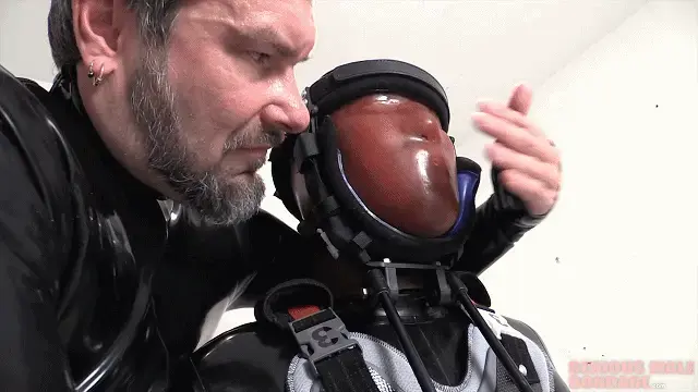 Mounted 一旦将他装入一个沉重的乳胶头套中，固定在医用支架上并安装在椅子上，呼吸和姿势训练就开始了。兰克真的知道如何利用无助的乳胶人。Our friend Rank employs a new tool from his arsenal of kinky gear. This is a medical halo brace which serves to keep his rubber gimp sitting upright and at full attention. Slouching gimps will not be tolerated. Once the gimp is enclosed in a heavy rubber StudioGum hood, secured in the medical brace and mounted to the chair, the breath and posture training begins. Rank really knows how to take advantage of helpless rubbermen. You can tell Rank's enjoying himself when you see that special smile on his face. I wonder what expression the gimp has on his face under that severe rubber hood? Visit Rank's rubber blog at