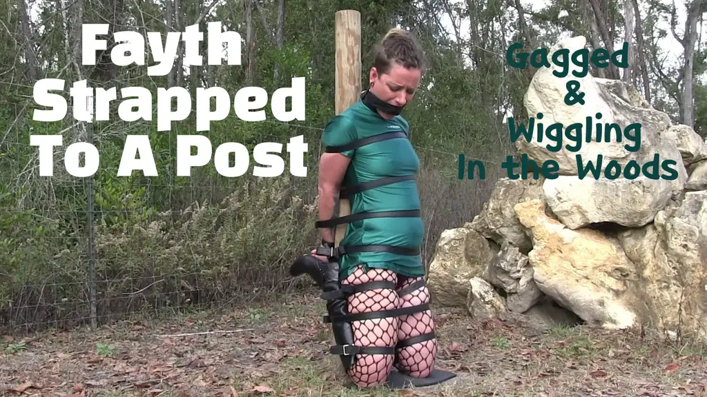 Fayth Strapped &amp; Gagged To Post Outside What do you get when you have a cemented pole in the ground, many black leather straps, a nice day, a soft shiny silky Lenox dress and a lover of bondage? Well, you get Fayth strapped on her knees to a pole that is not going anywhere for years and years. I on the other hand, do try to go somewhere. Though the straps are tightly binding my body in this kneeling position and the gag is keeping me a bit quiet, I still manage to struggle and move and do a little traveling around the pole. My scenery changes but your view stays the same as you keep an eye on me as I slowly navigate what feels like the biggest trip around the smallest wooden pole in the ground. I mph, I struggle and I keep myself busy as there really isn't much else to do other than test my binds and my inches of freedom to see just what I can do in my predicament. My blue eyes plead, my body moves, my mouth is quieter and i'm not going anywhere fast. Exactly how you like me, bound, struggling and outside in the fresh air getting my struggling exercising in for the day.<br><br>The question is, just how long will you keep me tied to this pole in this hot sun that is only getting warmer by the minute?<br>一根水泥柱插在地上，一堆黑色皮带，一个晴朗的日子，一件柔软闪亮的丝​​质莱诺克斯连衣裙，再加上一个喜欢捆绑的人，会发生什么？嗯，你会看到费丝被绑在一根柱子上，跪着，而且这根柱子一动不动，恐怕要好几年都挪不开。而我呢，却想办法动起来。虽然皮带紧紧地束缚着我的身体，让我跪着动弹不得，嘴里的口塞也让我几乎说不出话来，但我还是挣扎着，挪动着，绕着柱子转了一圈。我的周围景色在变化，但你的目光却始终如一，你注视着我，看着我缓慢地绕着这根插在地上最小的木柱，进行着感觉像是最长的一次“旅行”。我发出“嗯嗯”的声音，挣扎着，让自己忙个不停，因为除了试探我的束缚和那一点点自由之外，我实在没什么别的可做的，看看在这种困境下我究竟能做到什么程度。我的蓝眼睛里满是哀求，我的身体在动，我的嘴巴越来越小，但我却寸步难行。正合你意，我被绑着，挣扎着，在户外呼吸着新鲜空气，做着我今天的“挣扎锻炼”。<br><br>问题是，你到底要把我绑在这根柱子上多久？在这烈日下，每一分钟都在升温。