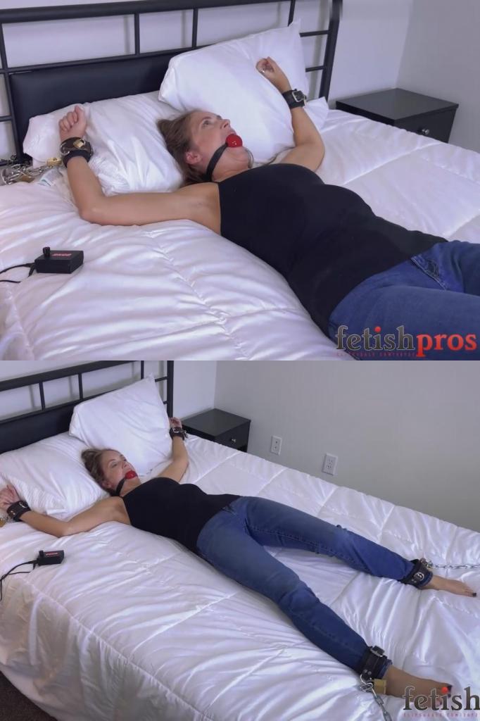 Rachel Adams Straps and Locks Herself Into Magnetic Self-Bondage with MagBound &amp; Retrotimer 瑞秋·亚当斯身穿背心和蓝色牛仔裤，赤脚走进卧室，开始了她的自我束缚冒险。她从床头柜上拿起一个红色球形口塞塞住嘴，然后用挂锁将皮质脚铐分别锁在床架上，最后将左手腕固定在床头的链条束缚带上。锁好右手腕的束缚带后，她设置了一个5分钟的倒计时，并将金属片对准MagBound磁力锁——瞬间将自己牢牢锁住。<br><br>她用力拉扯了几下，测试磁力锁是否牢固，但锁纹丝不动。她无助地被束缚着，在倒计时结束前挣扎着，等待着时间归零，这样她才能最终解开束缚，安全而满足地结束这场磁力自我束缚冒险。In a tank top and blue jeans, Rachel Adams walks barefoot into the bedroom and begins her self-bondage adventure. She picks up a red ballgag from the nightstand and gags herself, then secures each leather ankle cuff to the bed frame with padlocks before fastening her left wrist into a chained restraint at the headboard. After locking her right wrist cuff in place, she sets a 5-minute Retrotimer and brings the metal plate to the MagBound magnetic lock—instantly trapping herself in position.<br><br>She tests the connection with several strong tugs, but the lock doesn’t give way. Helplessly restrained, she struggles against the cuffs as the seconds tick down, waiting for the timer to reach zero so she can finally release herself and bring her magnetic self-bondage adventure to a safe, satisfying end.