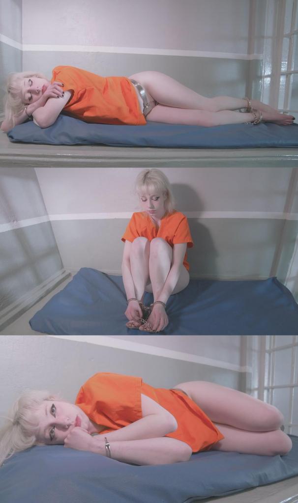Prisoner Kora Summers Locked In Chastity Belt - Barefoot Blonde Prison Inmate Girl Locked Up in a Ce Prisoner Kora Summers Locked In Chastity Belt - Barefoot Blonde Prison Inmate Girl Locked Up in a Cell 23 Hours a Day and Made to Wear a Steel Chastity Belt Handcuffs & Shackles<br>Kora 因又一次违反狱规而被关进了惩戒禁闭室。这一次，她因在牢房内自慰而被抓个正着；作为惩罚，除了在牢房内被戴上手铐脚镣之外，她还被迫戴上一条贞操带——且在整整30天内都不得将其取下。此外，Kora 全身上下仅有一件橙色的囚服上衣可穿，这使得她所戴的贞操带及光裸的双腿完全暴露在外，一览无余。<br><br>这是一段时长略少于30分钟的完整实录，展现了这位女囚在“贞操禁闭”状态下度过的又一个漫长日子。她在蓝色的囚室床垫上拖着沉重的镣铐挪动身躯，不时调整着身上的锁链和贞操带，试图寻找一个稍感舒适的姿势。在这里，除了盯着四壁发呆，或是透过铁窗凝视偶尔巡逻经过的狱警之外，她别无他事可做；而在这些狱警面前，她更是毫无隐私可言。目之所及，四周尽是混凝土监狱那令人窒息的荒凉与冷酷。<br><br>她盘腿而坐，面朝牢房那空荡荡的墙壁，这一坐便是约十分钟。随后，她躺了下来稍作歇息——但这绝非为了小憩入睡。因为一旦被狱警发现她在白天睡觉，等待她的将是更为严厉的惩罚。想要如此轻易地打发掉这禁闭室里的漫长时光，对她而言绝非易事。<br><br>最终，Kora 重新直起身子，靠坐在牢房的一角，百无聊赖地拨弄着贞操带上的锁扣。即便她真有办法将其解下，又能有何意义呢？狱方只会以此为由，对她施以更为严苛的惩罚作为报复。时光在此流逝得如此缓慢，而她在这禁闭室中仍需熬过漫长得多的岁月。Kora is locked up in disciplinary confinement for yet another infraction of the rules. This time she was caught masturbating in her cell, so the punishment will be that in addition to being handcuffed and shackled in her cell, she will be made to wear a chastity belt that isn't coming off for the full 30 days. Kora will also only have an orange prison uniform scrub top to wear, leaving her chastity belt and bare legs on full display.<br><br>This is an uncut just under 30 minute view into yet another day locked up in chastity for this inmate. She shuffles around on her blue prison mattress, adjusting her chains and her chastity belt trying to get comfortable. There's nothing to do but stare at the walls, or out the bars at the occasional patrolling guards from whom she also has zero privacy. Everywhere around her is the bleakness of a concrete prison.<br><br>She sits cross legged for about ten minutes facing the blank wall of her cell. After that, time to lay down for a bit, but not to nap. She will be in more trouble if the corrections officers catch her napping during the day. She doesn't get out of passing her time here as easy as that.<br><br>Finally Kora finds herself sitting up right and against the corner of the room and playing with the lock on the belt. Even if she got it off, what would the point be? They would only make the punishment worse as a response. Time passes so slowly, and she will be in here for a lot longer still.