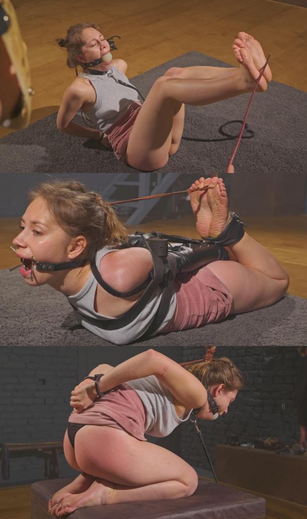 Little Agness - Strict Bondage Training with Ballgag, Ring Gag and Leather Armbinder Hogtie 在这段视频里，小艾格妮丝接受了一堂严格的服从课。<br><br>我用牵引绳把她带进我的地牢，她的双手被反绑在背后，用两副金属手铐固定住：一副铐住她的手腕，另一副铐住她的手肘。我踮着脚尖牵着艾格妮丝走来走去，然后让她跪下，把她的头发扎成一束，绑在手铐上。之后，我把一个白色的大球形口塞塞进她的嘴里。<br><br>因为艾格妮丝个子很小，几乎任何口塞在她面前都显得很大——但她的嘴却能容纳下尺寸惊人的实心球形口塞。口塞塞好后，我把她牵到一个立方体上，让她跪下，然后把牵引绳扣在项圈上。这个姿势很适合打屁股，所以我用鞭子抽打她的屁股，直到它开始泛红。快结束的时候，我解开了她手上的手铐。<br><br>惩罚完屁股之后，我把她从立方体上抱下来，让她坐在地上，抬起她的双腿，用藤条狠狠地抽打她光裸的脚后跟。<br><br>然后，最后的改造开始了。<br><br>我解开她的手铐，把她的双臂反绑在背后，用皮质臂套固定住，收紧她身上的皮带，然后把白色的大球形口塞换成蜘蛛形环形口塞。接着，我把她放在地上，用皮带把她捆成猪蹄状。<br><br>我非常喜欢最终的捆绑效果——紧凑、美观、牢固，艾格尼丝根本没有机会挣脱。为了完成这个姿势，我把她的头发和脚趾绑在一起，然后走开，留下小艾格尼丝独自一人，被皮衣和绳索紧紧束缚着。Little Agness receives a strict obedience lesson in this clip.<br><br><br>I bring her into my dungeon on a leash, hands behind her back, secured with two pairs of metal handcuffs: one pair on her wrists, the other locking her elbows. I lead Agness around on tiptoes, then place her on her knees, gather her hair into a bundle, and tie it back to the elbow cuffs. After that, I push a large white ballgag into her mouth.<br><br><br>Because Agness is so tiny, almost any gag looks huge next to her face - and yet her mouth can handle impressively solid ballgag sizes. Once the ballgag is in, I lead her onto a cube, place her on her knees, and clip her leash downward by the collar. It's a perfect position for spanking, so I work her ass with a whip until it starts turning a warm pink. Near the end of the spanking, I remove the elbow cuffs.<br><br><br>After the ass punishment, I take her down from the cube and make her sit on the floor, lifting her legs up so I can give her bare heels a short bastinado session with a switch.<br><br><br>Then the final transformation begins.<br><br><br>I remove the wrist cuffs, place her arms into a leather armbinder behind her back, tighten straps around her body, and replace the large white ballgag with a ring-gag spider gag. Then I lay her on the floor and tie her into a tight hogtie with belts.<br><br><br>I really love the way this final hogtie turns out - compact, aesthetic, and secure, with no realistic chance for Agness to work her way out. To complete the position, I connect her head by the hair to her toes, then step away and leave Little Agness alone, tightly restrained in leather gear and rope.
