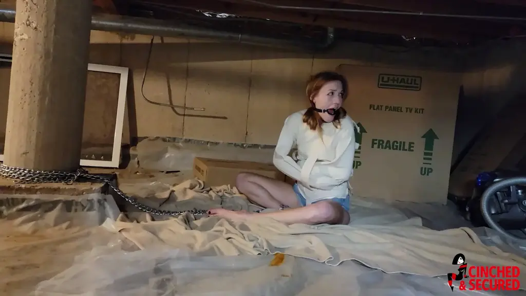 Cara Day's Magic Strait Jacket Woes! Cara answered an ad to serve as an assistant for a magician. She loved being on stage and always delighted in knowing how the tricks were done, so she was very anxious to get the gig. She scoffed as the magician explained that he did not use tricks and that all his amazing feats were accomplished through genuine magical spells! Her skepticism turned to amazement as he case the first spell and a very tight straitjacket materialized around her body! She struggled and squirmed, pulling at the straps and seeking a way out, but the magic held her fast. Unfortunately, the magician had not yet learned the spell to get her OUT of the jacket! When he tried to magically remove her, a ring gag grew in her mouth instead! He promised to look through his book of spells in order to see what he could do and left her, gurgling, groaning and drooling as she tried in vain to effect an escape on her own! Finally, the man returned and tried one last spell, but instead of releasing her from the strait jacket, she disappeared! She re-materialized in a creepy basement, chained to a post, all by herself with no way out!<br><br>