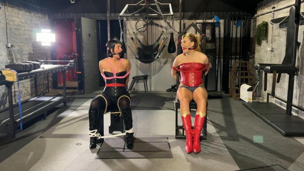 Wonder Ariel and Dark Wonder Sarah Wild Captured and led into slavery 神奇女侠艾瑞尔·安德森始终致力于保护无辜者，拯救世界免受一切邪恶和卑鄙阴谋的侵害。然而她却浑然不知，自己有一个宿敌，一心想要阻止她履行天职。黑暗神奇女侠莎拉·怀尔德计划俘虏神奇女侠艾瑞尔，让她动弹不得，并将她永远囚禁。然而，另一个反派偶然发现了黑暗神奇女侠的计划，并对这两位女英雄另有图谋。看着爱丽儿被莎拉抓住，戴上项圈，力量被剥夺，变得虚弱无助。艾瑞尔发现自己被牢牢地绑在一张束缚椅上，无处可逃。莎拉得意洋洋地炫耀着自己的胜利，并用一个硬邦邦的球形口塞堵住了艾瑞尔的嘴。然而，反派角色随后出现，扭转了局势，莎拉发现自己被戴上了项圈，毫无反抗之力。接下来，莎拉发现自己被绑在艾瑞尔旁边的一把椅子上，两人都抗议并互相指责对方造成了她们这种无助的困境。椅子绑吊刑，双腿绑在环上并互相绑住。胯部绳索。塞满口塞和裂口塞。胶带封口两人被捆绑在一起，虽然彼此触手可及，但却被固定在地板上的环上，无法够到对方解开绳索。最终，两位女主角都被重新束缚，失去了反抗能力，她们被告知了自己的未来，然后被戴上项圈，带走，开始了她们的奴隶生涯。<br>Wonder Woman Ariel Anderson is always out to protect the innocent and save the world from any and all evils and despicable plots. Little does she know she has an arch rival who wants to stop her from doing her natural vocation. Dark Wonder Woman Sarah Wild has plans to capture and render wonder Ariel helpless and keep her in bondage forever. However another villain has stumbled on Dark Wonder Woman's plans and had ideas and plots of his own for both of the female damsels.Watch as Ariel is taken by Sarah and collared and rips her powers from her leaving her weak and helpless.Ariel finds herself bond securely to a bondage chair with no means of escape. Sarah gloats at her victory and silences Ariel with a harsh ball gag.However the Villain then appears and turns the tables on Sarah and she finds herself collared and powerless.Next Sarah finds her self secured to a chair next to Ariel and they both protest and blame each other for their helpless predicament.Chair tied Strappado tied with legs tied to rings and each other. Crotch ropes. Stuff and Cleave gagsTape gagsHogtied within reach of each other but secured to rings in the floor and unable to reach each other to remove the ropes.Finally both recollared and powerless both superheroines are informed of their future and leashed and led away for a life in slavery