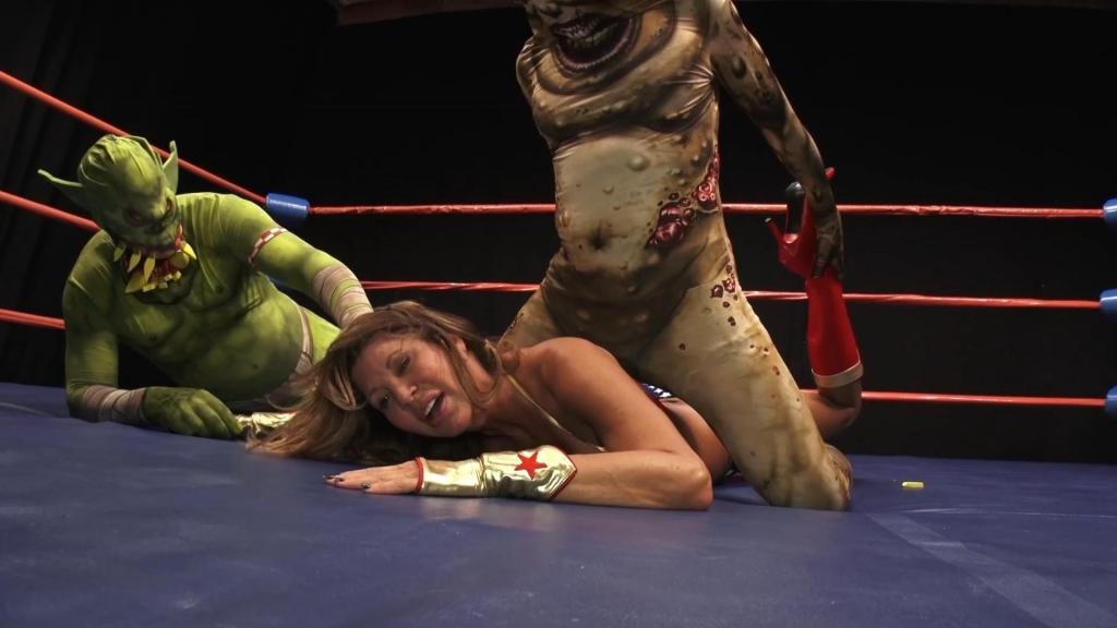 SUPERHEROINE AGENDA-MONSTERS UNLEASHED 这是终极怪物大乱斗，超级女英雄好莱坞感觉自己斗志昂扬，准备迎战……可惜太迟了，巨大的绿色怪物在她还没反应过来之前就扑了上来，但我们知道发生了什么，绿色怪物和这个丑陋的东西不停地殴打她，然后把她抱起来，扛着她，把她扔到自己的膝盖上。经过一番绿色折磨，超级霍莉终于奋起反击，用她惊人的绝招制服了绿巨人——一场势均力敌的超级大战就此展开，最终超级霍莉使出浑身解数，将绿巨人击倒在地，战斗结束了……不，还没完——最丑陋的怪物出现了，丑陋的怪物再次用他野蛮的擒拿和拳脚痛击可怜的超级霍莉，超级霍莉再次竭尽全力，最终制服了这个怪物，终于结束了……不，还没完，绿巨人醒了过来，现在和丑陋的怪物联手对付可怜的神奇女侠，他们使出了许多精彩的双人折磨——比如他们把她按在角落的柱子上，从外面分别控制住她的一侧，把她扭来扭去，这仅仅是只有怪物才能施展的双人折磨的开始——为了真正羞辱她，超级真实的双人折磨，你一定会喜欢的！！！！！<br>This is the ultimate monster mash, Super Hollywood is feeling very feisty, ready to take on … too late the big Green Monster is on her before she knows what hit her, but we know what hit her, Green Monster and this ugly thing just keeps pounding on her, then picks her up carries her and drops her on his knee. Finally after so much green torture Super Holly fights her way back working some of her amazing holds on Big Greenie – a back and forth super battle ensues until finally wonder woman works her magical fighting and has the Green Monster down and out, it’s over… nope – here comes the ugliest monster of all and Ugly Monster starts the beat down on poor Super all over again with his savage holds and blows and again Super musters all her strength to eventually also subdue this monster and finally done… nope, Greenie wakes and now works with Ugly to double team poor Super Holly, they do so many great double destroys – like when they bend her around the corner post as from outside they each take a side of her and bend and this is just the beginning of double torment that only monsters can preform — for real debasement they pull her top down — super real Double Trouble and you will love it !!!!!