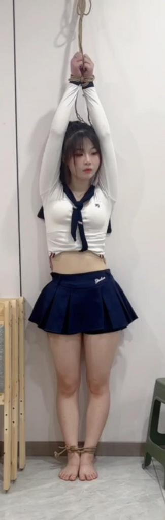 美女吊缚放置 身穿裙子的小萝莉裸足被吊在墙边，然后偶尔对话。最后绳子脱落蹦跳着自救