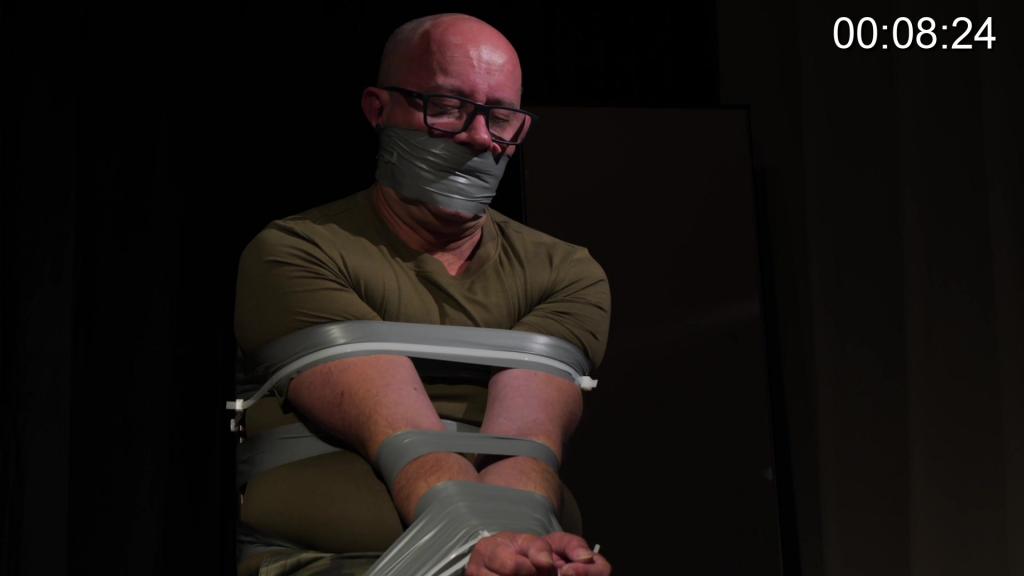 Louis - Escapology The Isolation Files I - The Chair Tie Louis has 1hr to escape a stringent chair tie with tape, reinforced by zipties, even on his fingers. He is gagged with wraparound electrical tape. If he cannot make it at 30 mins he will gain a pair of scissors to help, but his mouth will be stuffed with sponge and he will be blindfolded with electrical tape. Wish Louis good luck in his predicament