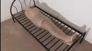 Gagged, Nylon Encased, Bed Frame Tied and Buzzing 伪娘<br>Nina has been nylon encased head to toe after having her mouth stuffed with panties and nylons. she has also been tied very tightly to a bed frame and covered over. Unable to move at all even when she's buzzing with the attached vibrator 