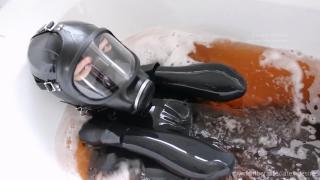 Relaxation bath in heavy rubber A rubberdoll is relaxing in the bathtub. She breathes in the scents and smells through her gas mask.