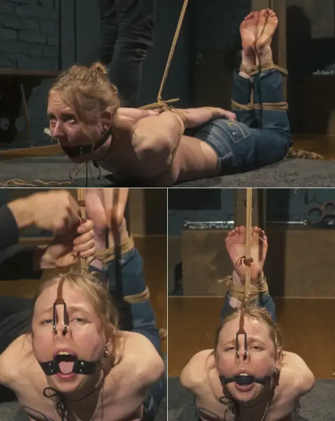 Mandy - Very Tight Topless Pole Hogtie with Ball Gag and Nose Hook By John<br><br><br>Mandy is sitting patiently in her jeans and tank top, waiting for me to begin. I put her on her knees and remove her top, leaving her breasts completely exposed.<br><br><br>Her arms are tightly bound behind her back with rope. I carefully tighten every wrap, drawing her wrists and elbows close together. I also secure a rope to her hair, preparing her for the nose hook that will be added later.<br><br><br>After fitting Mandy with a ring gag, I place her on her stomach and bind her legs firmly to the pole. Her bare feet rest beautifully against it as I tighten and secure the ropes. I then use more rope to lift her chest and body off the floor, displaying her exposed breasts while making her into an unusual and extremely strict pole hogtie.<br><br><br>The nose hook is attached, pulling from the rope in her hair, and her ring gag is replaced with a ball gag. I make the final adjustments and ensure that every rope is tight and the position pushes Mandy close to her limit.<br><br><br>Once everything is perfectly secured, I step away and leave her alone - topless, gagged, helpless, and tightly suspended in her demanding pole hogtie.<br><br><br>Enjoy!<br><br>