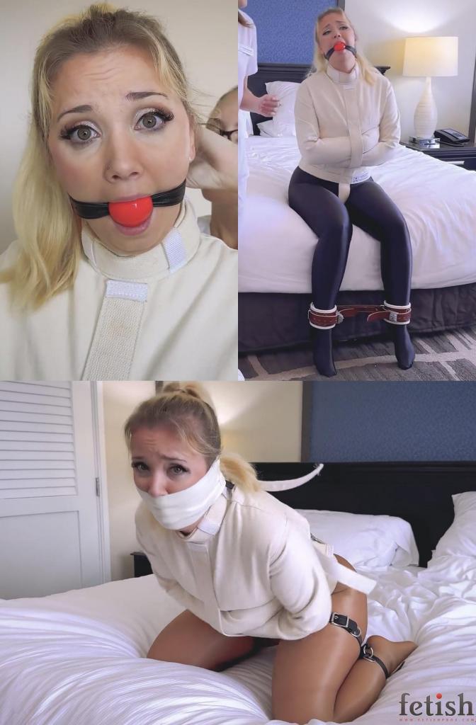 Straitjacketed Lil Missy UK Unwittingly Committed to Insane Asylum! 小心你签的东西：莉尔·米西·英国（Lil Missy UK）在填写护士瑞秋·亚当斯（Rachel Adams）的表格时就体会到了这一点。米西以为自己是在“承诺”寻找一位更好的医生，却误打误撞地把自己送进了精神病院！瑞秋给她穿上了一件有很多带子和扣子的束缚衣，然后又给她戴上了棕色皮质脚镣，与米西闪亮的黑色紧身裤形成了鲜明的对比，她的可怕命运就此展开。米西试图弄明白发生了什么，她一瘸一拐地在房间里走来走去，而我们也从头到脚仔细地观察着这一切。一个球形口塞限制了米西发出任何有条理的抗议。由于这一切都被一位看不见的精神病院摄像师记录了下来，米西用她那双蓝色的眼睛，近距离地向他发出恐惧的求救声，而瑞秋则把她带进卧室，脱掉米西的黑色紧身裤，露出下面的肉色连裤袜，用胶带紧紧地封住她的下半张脸，用黑色皮带把米西绑成青蛙状——然后把米西独自留下去“休息”，结果米西在无法逃脱的束缚中不停地扭动和呻吟。Careful what you sign: Lil Missy UK learns this when she fills out forms for nurse Rachel Adams. Missy thinks she’s “committing” herself to finding a better doctor, but mistakenly commits herself to a mental hospital! Her creepy fate unfolds as Rachel puts her into a straitjacket with loads of straps and buckles, and then brown leather ankle cuffs that contrast prettily with Missy’s shiny black leggings. Trying to understand what’s happening, Missy hobbles around the room, which we observe in top-to-bottom detail. A ballgag restricts Missy’s ability to protest in any coherent manner. Since all this is recorded by an unseen asylum videographer, Missy appeals to him with a fearful blue-eyed gaze in closeup, even as Rachel ushers her into a bedroom, strips off Missy’s black leggings down to nude pantyhose below, tightly tapes her lower face, and frogties Missy with black leather straps–before leaving Missy alone to “rest” which turns into unceasing writhing and moaning in her inescapable bondage.