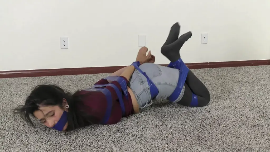 QT1456 Bethany Fontaine (is-qt-bf066) Bethany Fontaine run in from the backyard, already bound & gagged with blue electrical tape, and slams and locks the door behind her. She tries, POV, to gag talk and pantomime what happened to her, when she realizes the front door may be unlocked also. She runs to lock it (skidding a bit on the slippery floor in her tights), but the bad guy is already in the house! The very energetic Bethany puts up quite a struggle but she is no match for him and his many rolls of tape! 