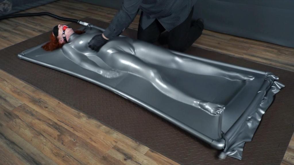 Girl with ball gag and mask, inside gray latex vacuum bed, tickling A girl wearing a blindfold and a red ball gag was being tickled inside a gray latex vacuum bed. She tried to escape, but the vacuum bed wouldn't let go, and the tickling became unbearable...